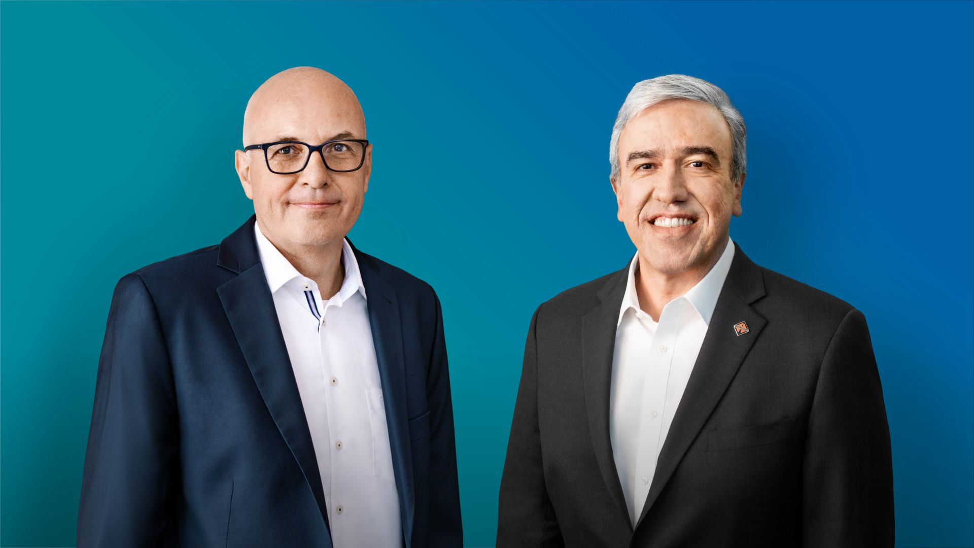 Image of Matthias Gründler (CEO TRATON SE, left) and Persio Lisboa (CEO Navistar Inc., right) in front of a blue background