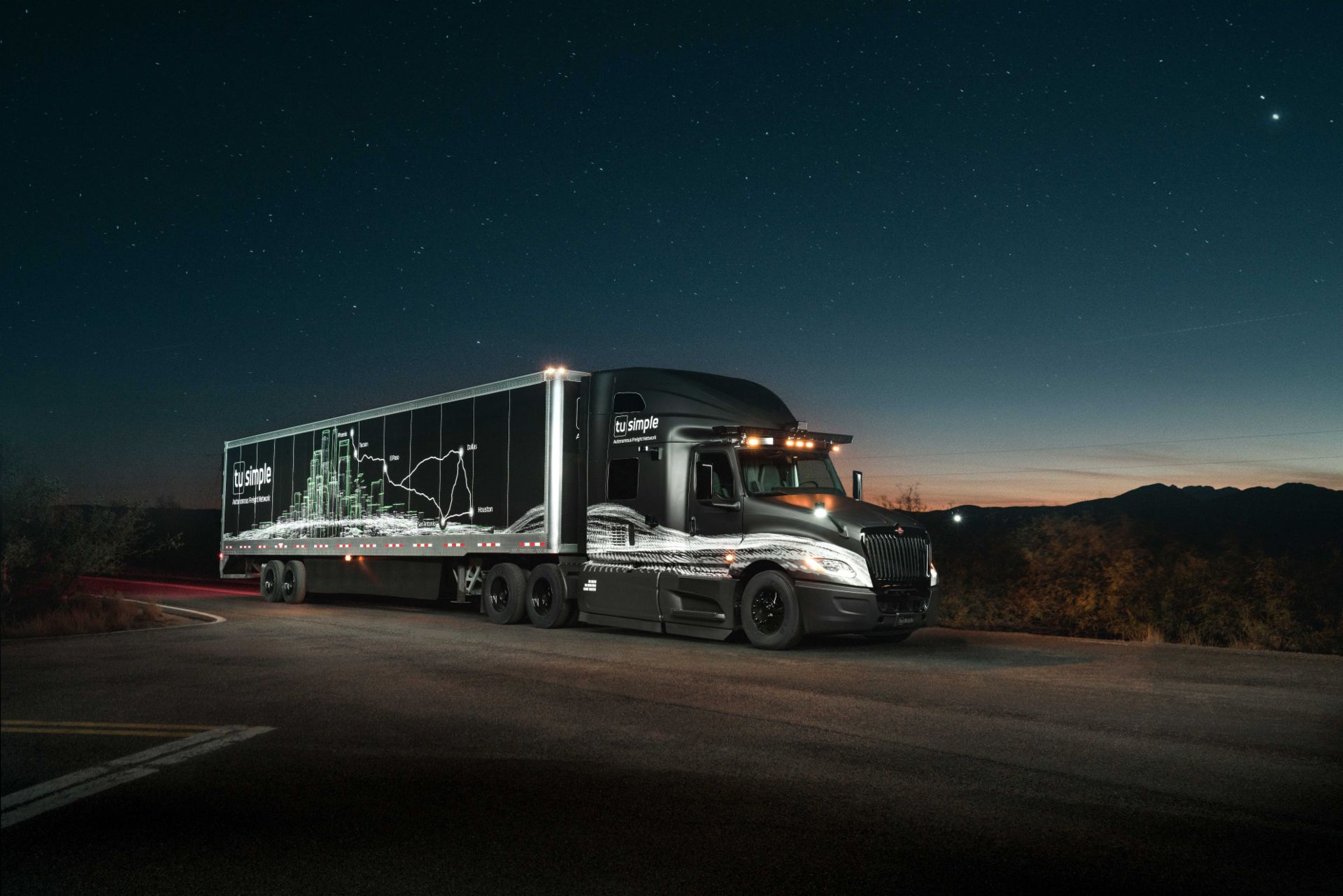 Image of an Level 4 autonomous class 8 trucks of TuSimple & Navistar at night