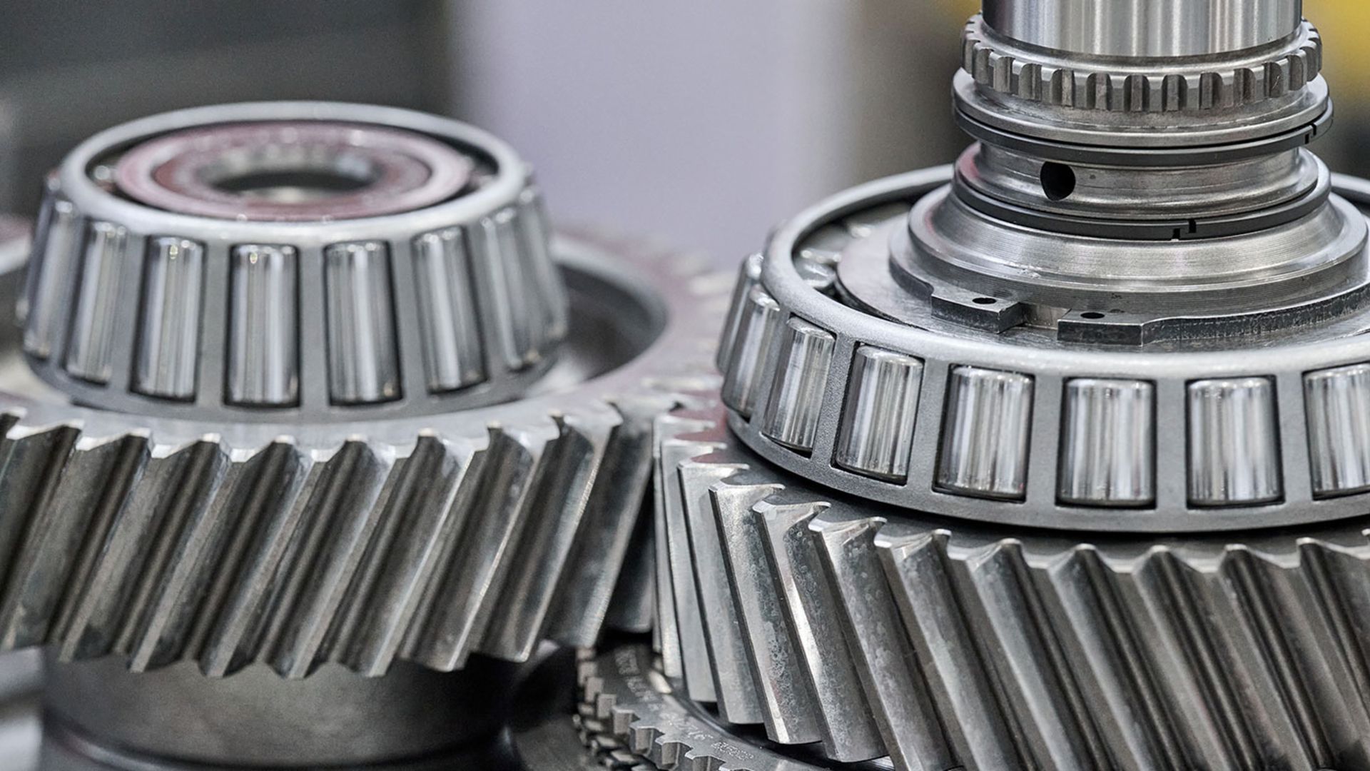 Detailed view of industrial cogwheels and tapered roller bearings in a mechanical assembly.