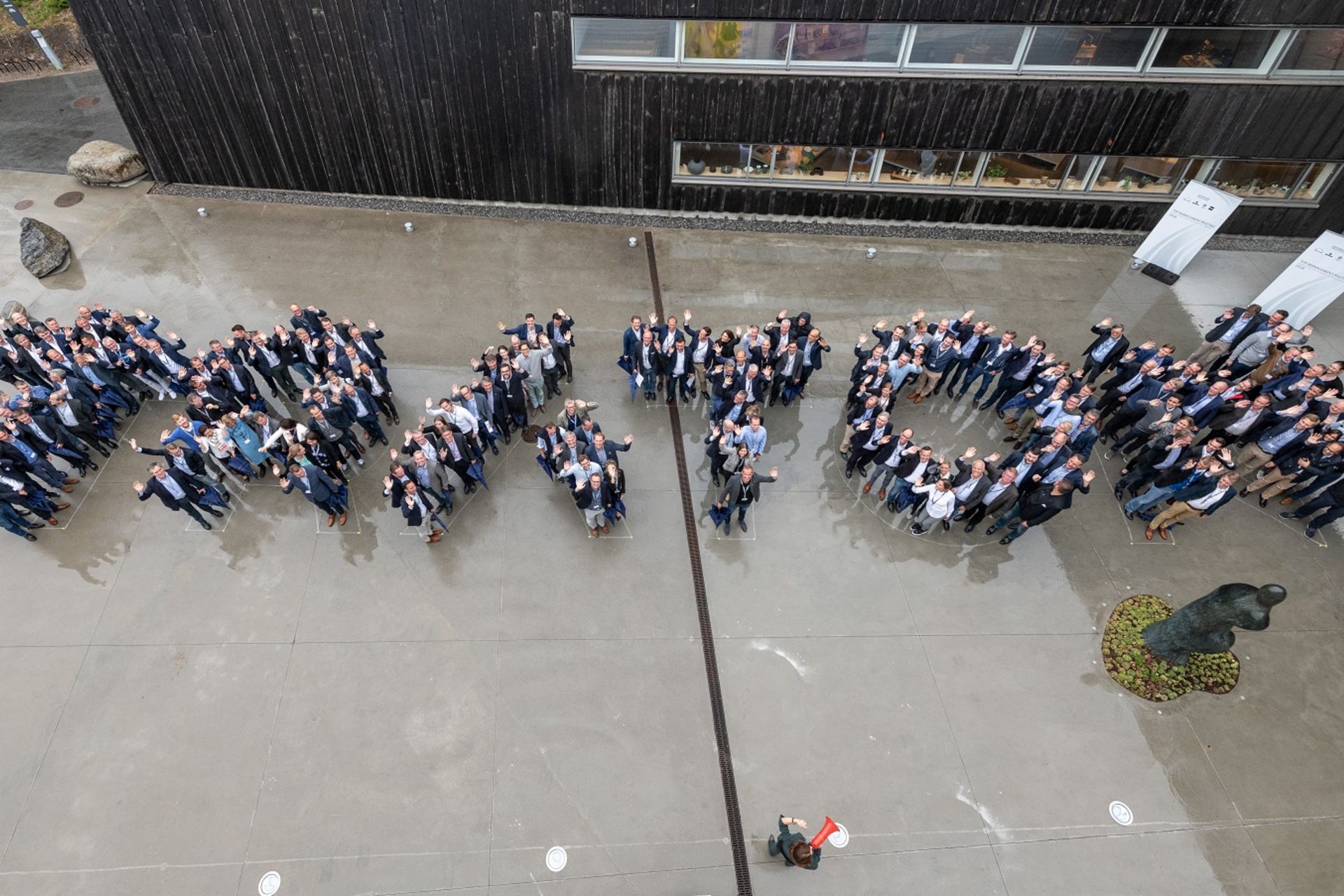 Mitarbeiter bilden TRATON Logo nach.
                 