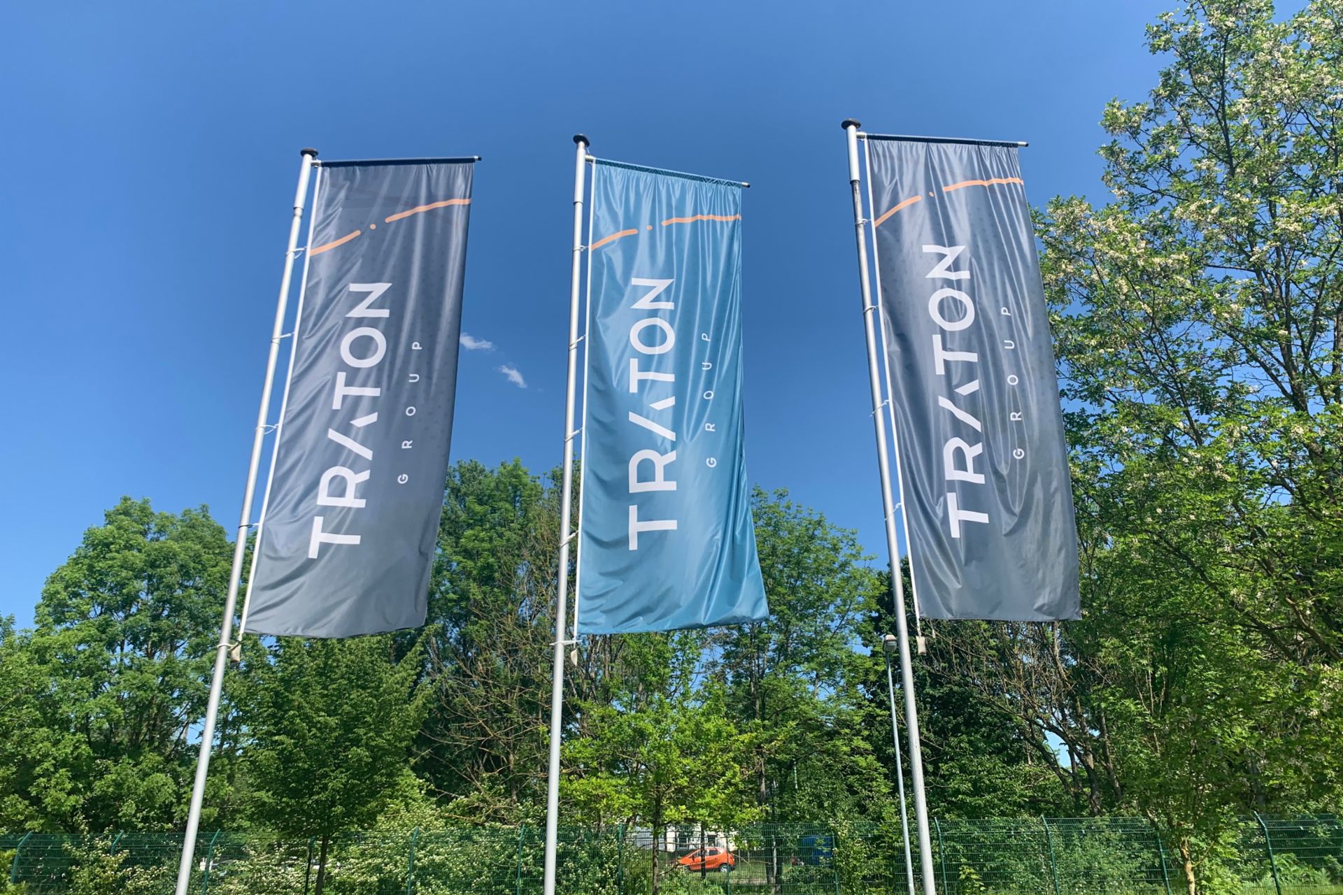 Three flags on the mast with TRATON logo
                 