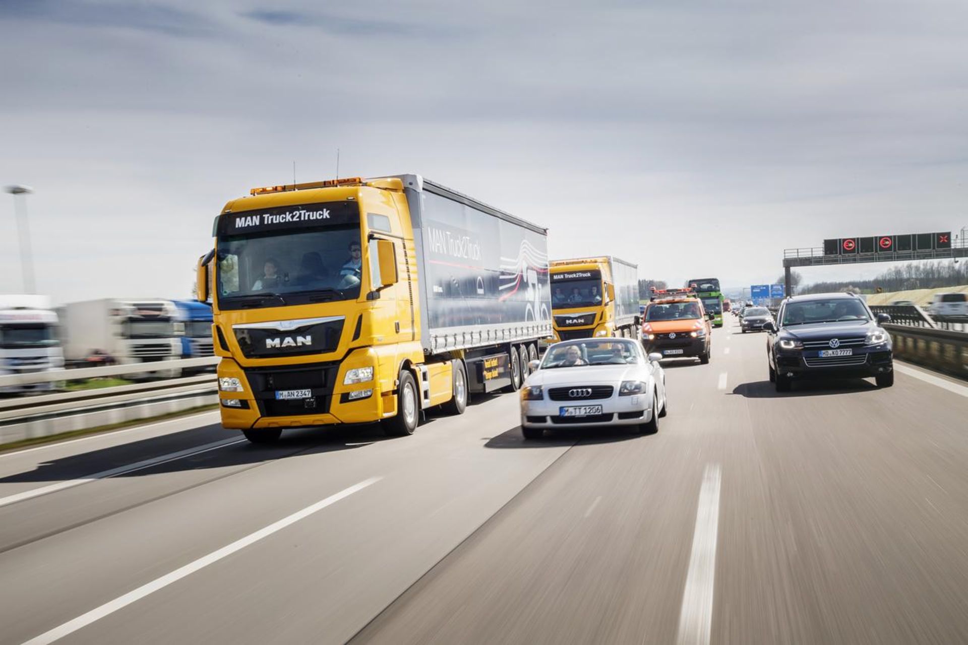 Truck (MAN) and several cars (Audi, VW) on a highway
                 