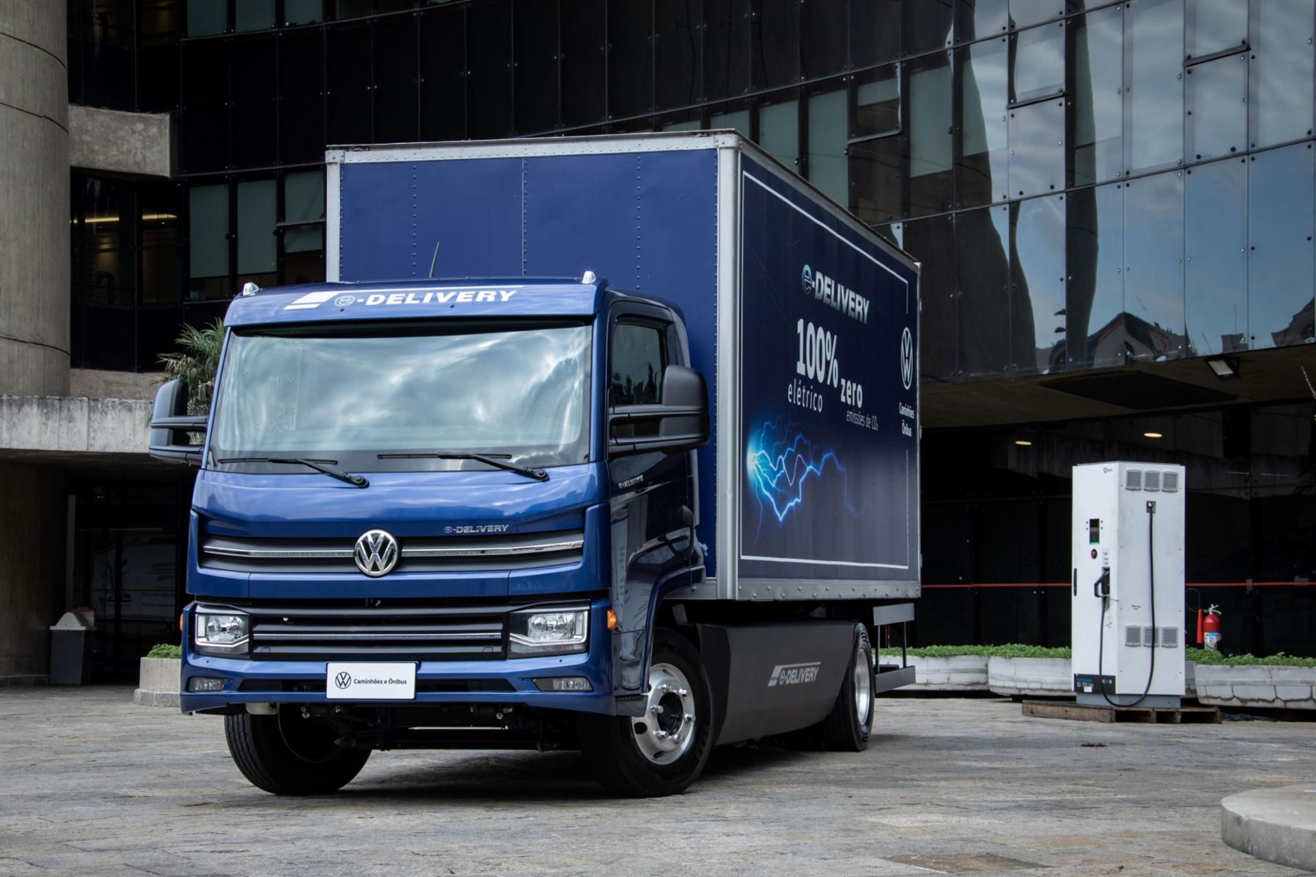 Blauer Volkswagen LKW neben einer Ladesäule
                     