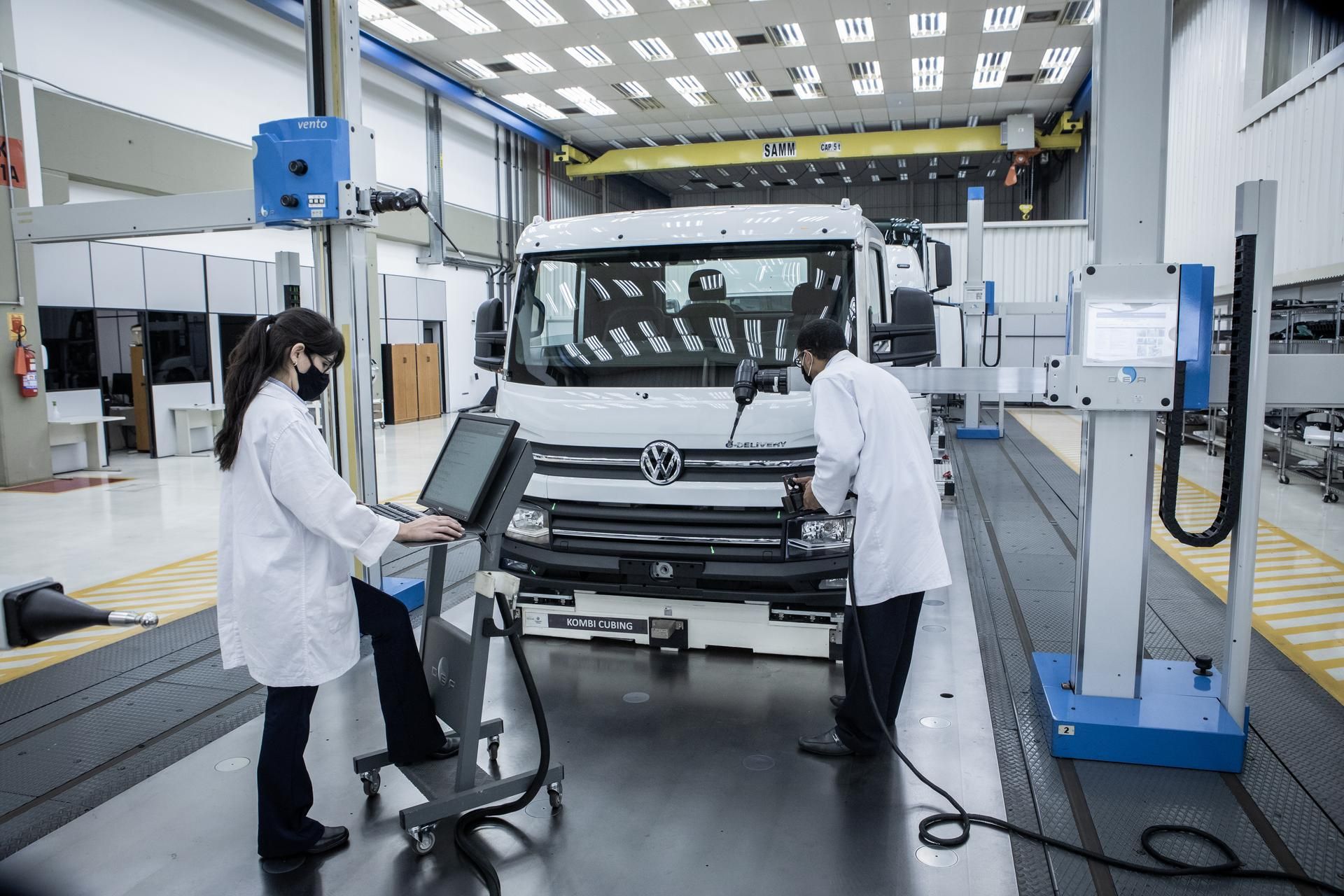 Ein Truck von Volkswagen wird von zwei Mitarbeitenden in der Produktion geprüft. 