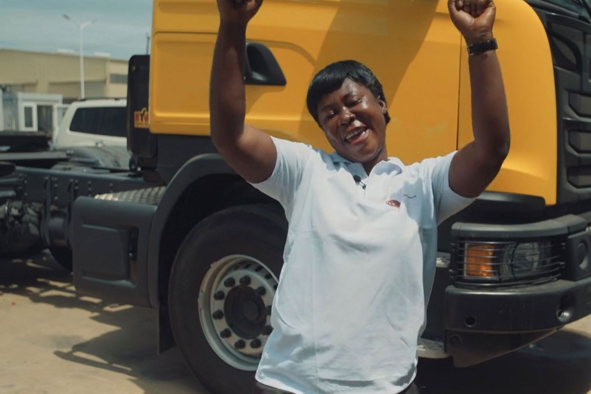Woman in Accra smiling in front of a truck