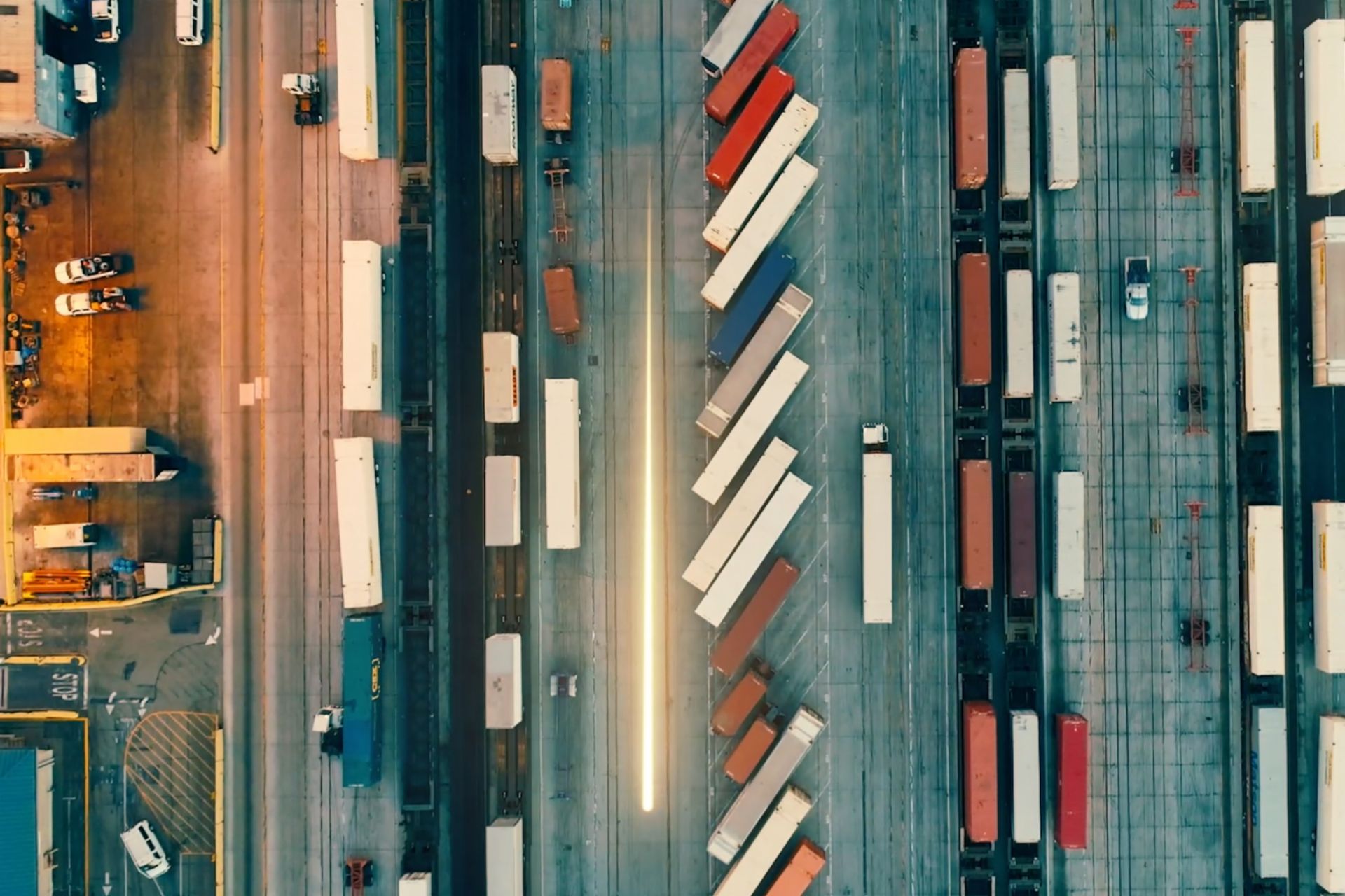 Eine Vogelperspektive zeigt viele Lastwagen die auf einer Straße aufgereiht sind