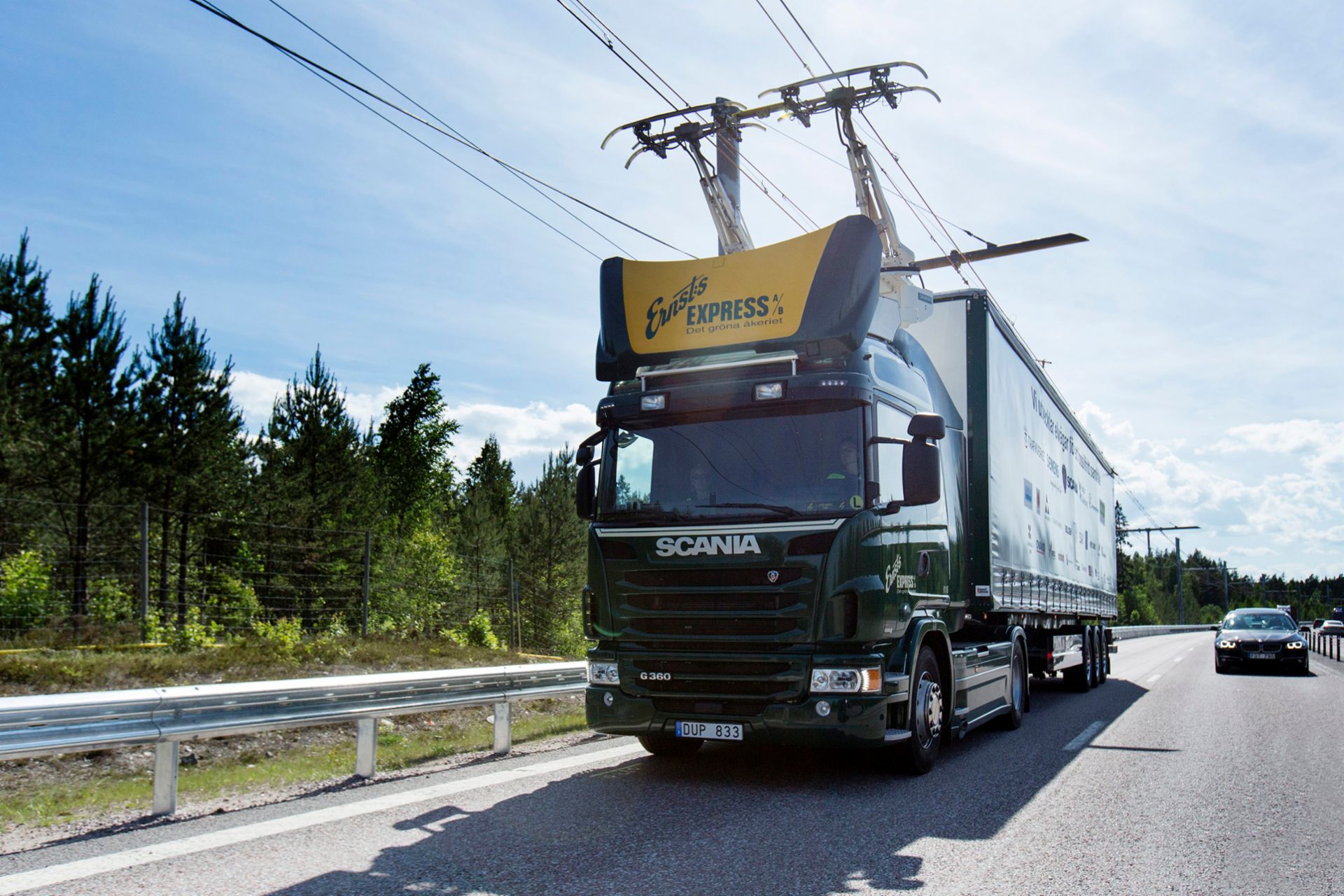 The Scania G 360 4×2 hybrid drives connected to overhead power lines.
                 