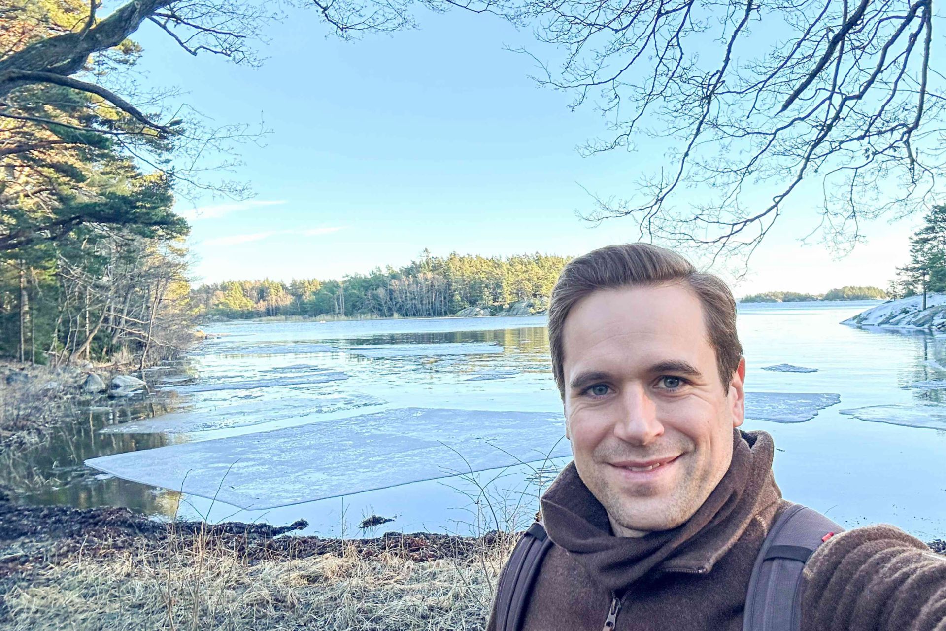 Selfi von Philipp Lassernig im Björnö Naturreservat. Im Hintergrund ein See umgeben von Wald.